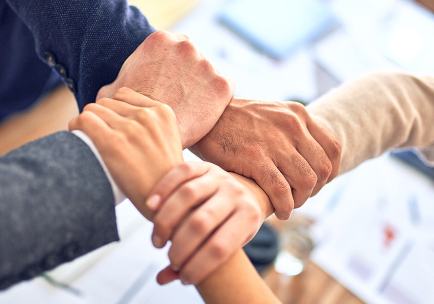 Group of people holding each-others wrists in a kind of bonding way